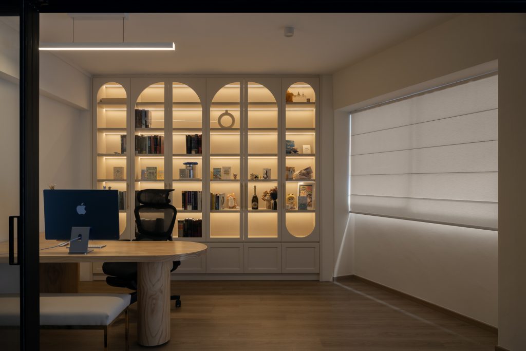 Professional home office with built-in shelving and ergonomic setup, designed by an interior design company in Singapore using commercial-grade solutions.