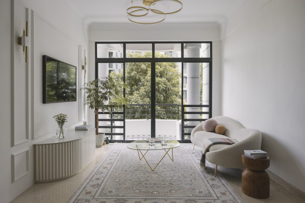 A white, Contemporary, French interior with a few plants. A rug adds character and flair to the room.